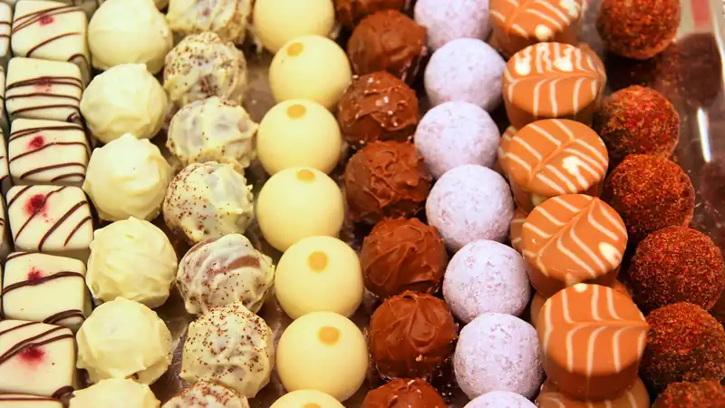 Vitrine de chocolats et de pralines alignés par saveur
